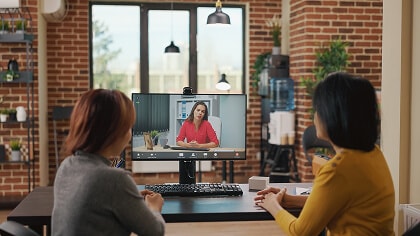Two women sitting infront of a computer