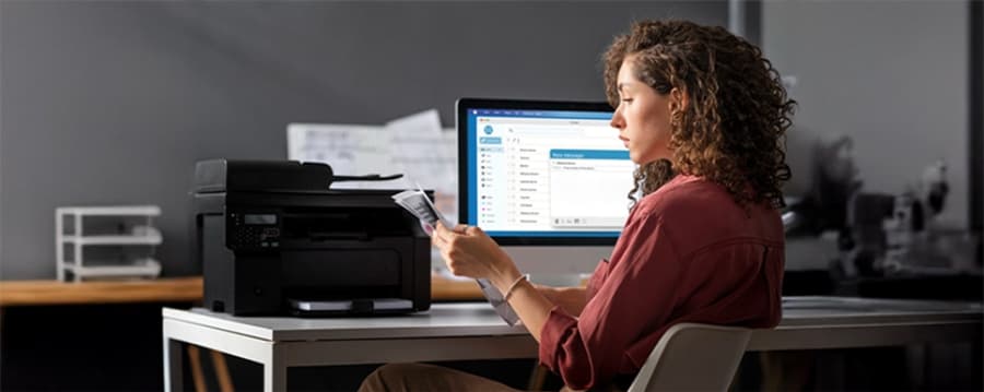 Person reading a document at a desk, representing the key capabilities needed in an AP automation solution.